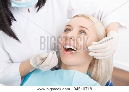 Woman having her teeth examined by dentist
