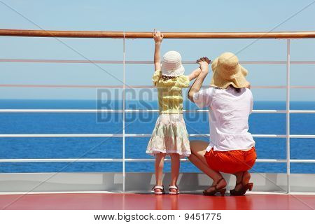 Bag mor og hendes datter, stående på dækket af Yacht og de ser langt ombord
