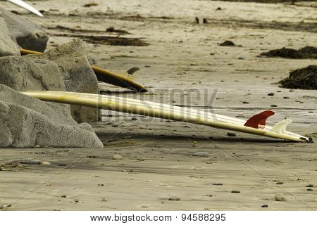 Surfboard Leaning On Rocks At Beach