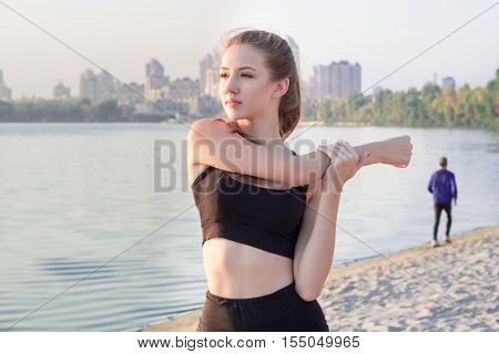 Young Fitness Girl Stretches Preparing For Training Workout Exercises Outdoor