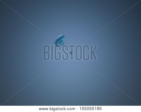 a man's blue parachute gliding in the blue sky