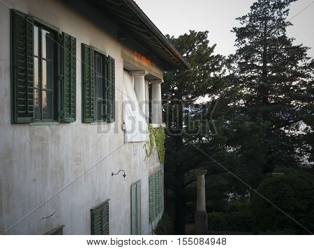 Mediterranean house with green shutters and white curtains