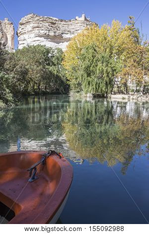 Alcala del Jucar Spain - October 29 2016: Jucar river boat of recreation in small lagoon in the central part of the town at the top of mountain limestone is situated castle of Almohad origin of the century XII take in Alcala of the Jucar Albacete province