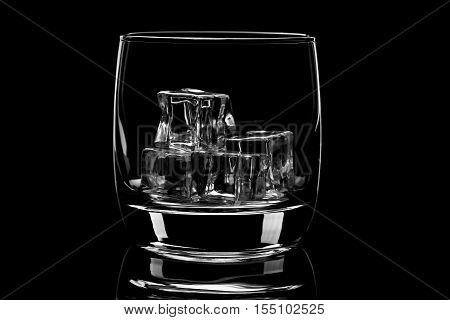 Empty glass filled with ice cubes. Nice reflection From the glass. Black and white.