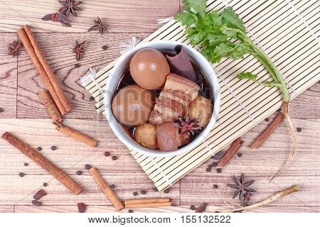 Thai Recipes : Stewed boiled egg with tofu and streaky pork ,call Khai Palo in Thai, take photo with herbs as Chinese star anise ,cinnamon,black pepper,cilantro roots and stems