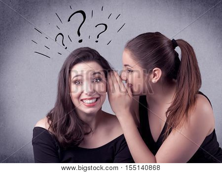 A teenager girl looking confused with drawn question marks above the head, while a girlfriend whispers something in her ear concept.