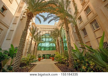 DUBAI, UAE - OCTOBER 14, 2016: The interior of the luxurious Al Qasr Hotel with palm trees.  The Al Qasr Hotel is part of the Jumeirah Group of hotels