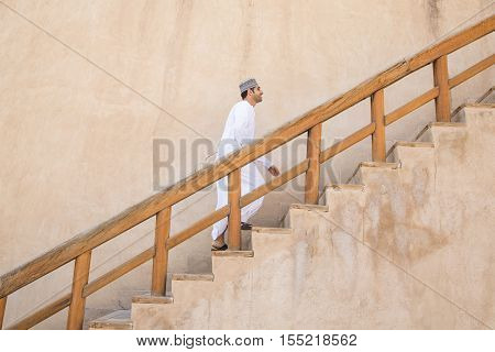 Omani Man Walking Up The Stairs In Nizwa Fort