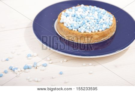 Traditional Dutch birth celebration biscuit with blue muisjes on wooden background