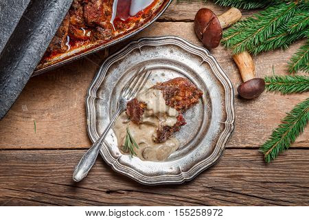 Venison prepared in a forest way on old wooden table