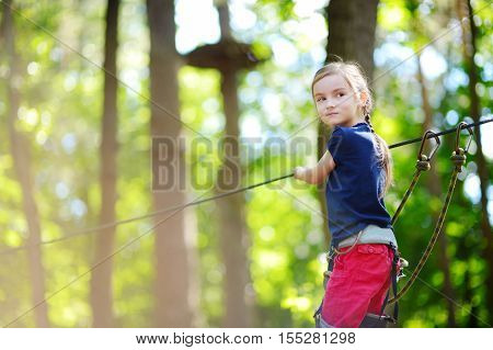 Adorable Little Girl Enjoying Her Time In Climbing Adventure Park