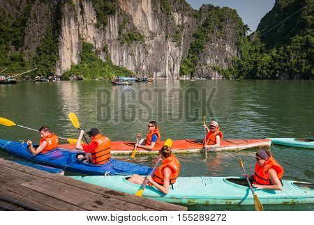 Halong Bay, Vietnam - September 2016: Tourists in kayaks paddling in Halong bay, Vietnam. Rental kayaks in Halong Bay.