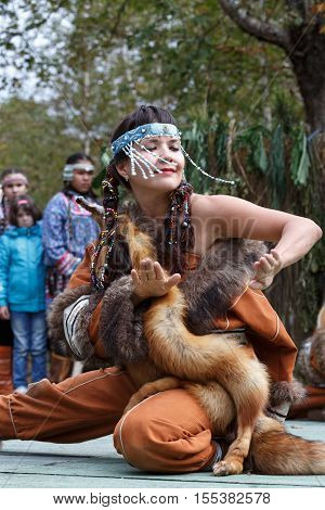 KAMCHATKA PENINSULA RUSSIA - SEP 14 2013: Public concert on Itelmen national holiday of thanksgiving nature Alhalalalay. Expression young woman (ensemble Northern Dawns) dancing in clothing aborigine of Kamchatka.