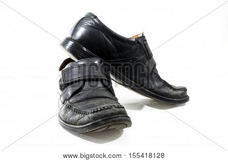 Old used and worn black leather shoes on a white background