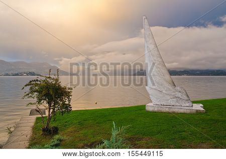 STRESA, ITALY. 26th October 2016. One of the three modern white carrara marble sculptures on Stresa's lakeside stands sentinel over Lake Maggiore at sunset.