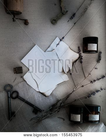 Sheets of burnt paper, cans and bottles, old keys, dry lavender. view from above.