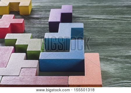 The concept of logical thinking. Geometric shapes on a wooden background. Tetris toy wooden blocks.