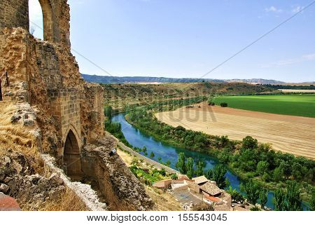 Paisaje natural con castillo viejo, río y campo