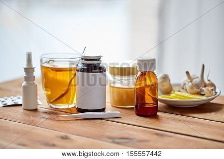 healthcare, traditional medicine, flu and ethnoscience concept - drugs on wooden table