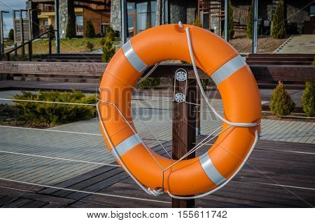 Red lifebuoy with rope  in port, picture with space for text or logo