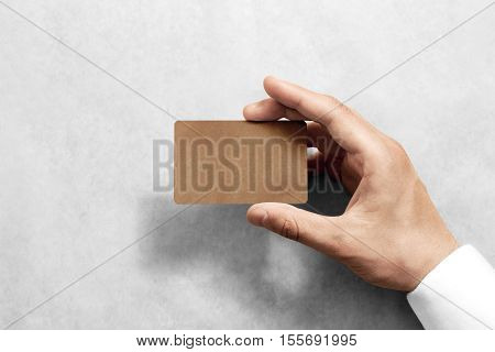 Hand hold blank craft card mockup with rounded corners. Plain kraft call-card mock up template holding arm. Hand made namecard display front. Check offset card design. Business branding.