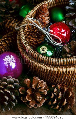 Vintage New year and Christmas decorations in woven bsket with pine cones