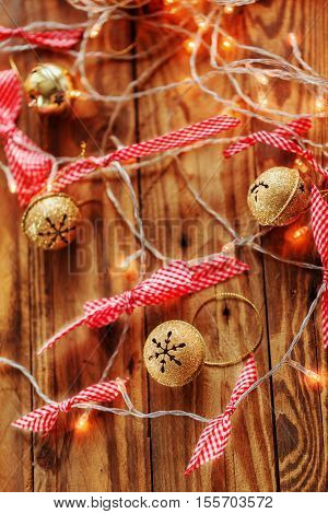 Metal Jingle Bells and Christmas Garland Light on wooden background. Christmas background