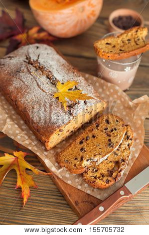 Homemade pumpkin cake with chocolate on wooden background. Autumn still life.