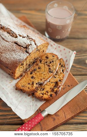 Homemade pumpkin cake with chocolate on wooden background.