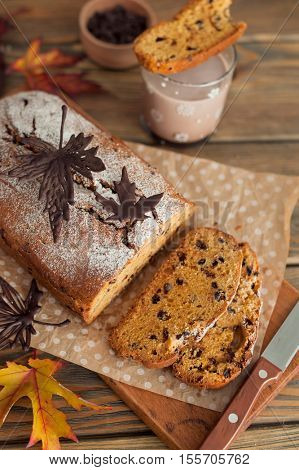 Homemade pumpkin cake with chocolate on wooden background. Autumn still life.