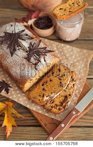 Homemade pumpkin cake with chocolate on wooden background. Autumn still life.
