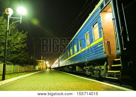 Train at midnight railway station. Opened door of railway carriage.