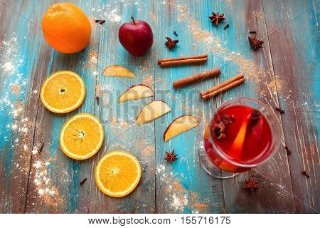 Orange, apple, cinnamom, anice, wine (mulled wine) on wooden background