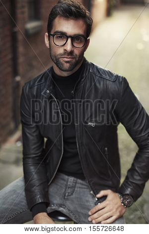 Cool guy posing in glasses and leather jacket