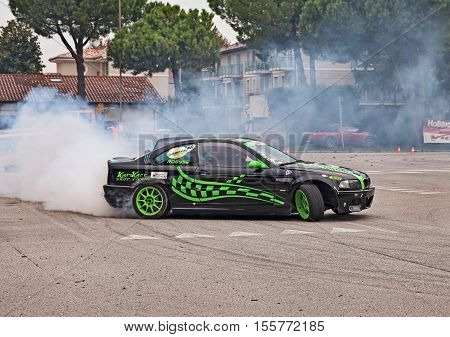 SAN PIETRO IN VINCOLI, RAVENNA, ITALY - OCTOBER 23: driver and co-driver on a drift racing car BMW in action drifting with smoking tires  in 