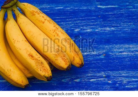 Bananas on a blue wooden board, picture with space for text or logo