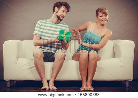 Young Man Giving Offended Woman Gift Box