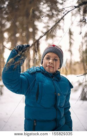 boy in the winter woods under the branches