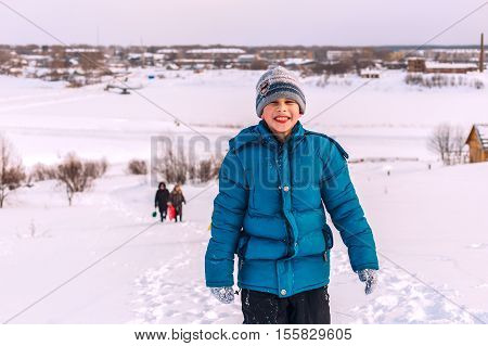 young boy in winter up the hill on the banks of the river
