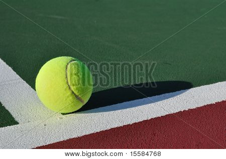 Pelota de tenis amarilla en cancha