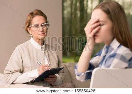 Probation Officer Taking Notes While Talking With Teenager