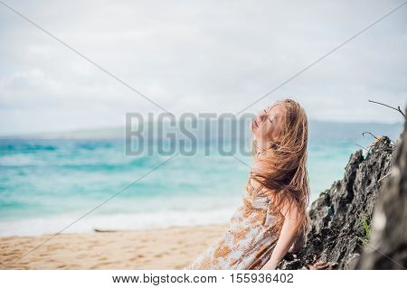 A Girl Sits On A Rock On The Beach Of Boracay