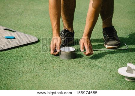 Greenskeeper Cutting A Golf Hole