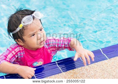 Little Asian Girl Wearing Waterproof Sunglassses Try Swimming Alone In Swimming Pool, Outdoor