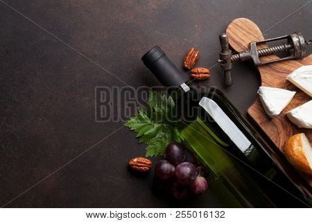 Wine, cheese, grape and nuts. Top view with space for your text
