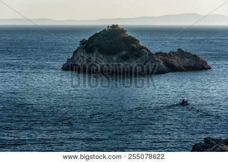 Motor Boat Towards The Small Lonely Inhospitable Uninhabited Island In Blue Ionian Sea In Greece