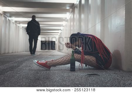 She Crying Of Separation From Lover. Girl Sits With A Bottle Of Alcohol And Worries About Unrequited