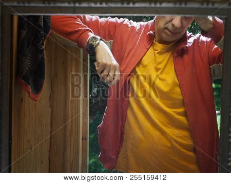 A Man Seems Pensive Standing In A Doorway, Reflection In A Mirror Cropped Shot