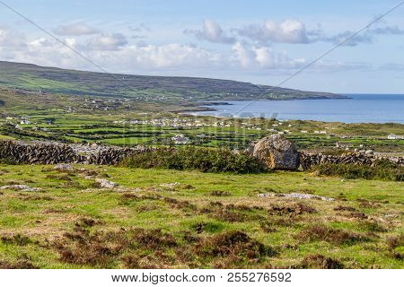 Farm Field And Stone Wall With Farms And Houses In The Fanore Village In Background