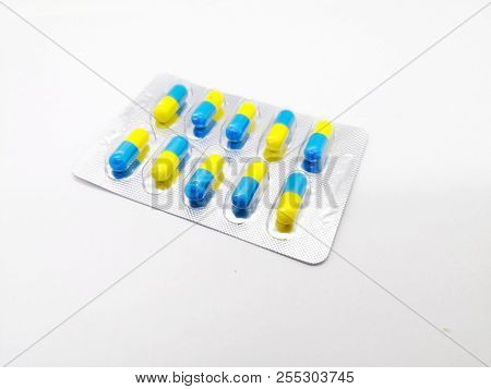 Medication And Healthcare Concept. Many Blue-yellow Capsules Of Piroxicam 20 Mg., That Are In Silver